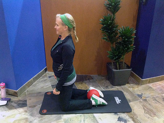 Image of Laura Coleman demonstrating kneeling ankle squeezes