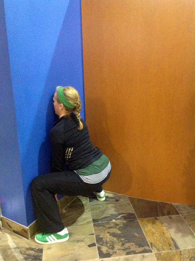 Image of Laura Coleman Demonstrating Sumo Squats against a wall start position