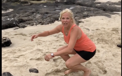 Image of Laura Coleman Waite demonstrating a squat on the beach